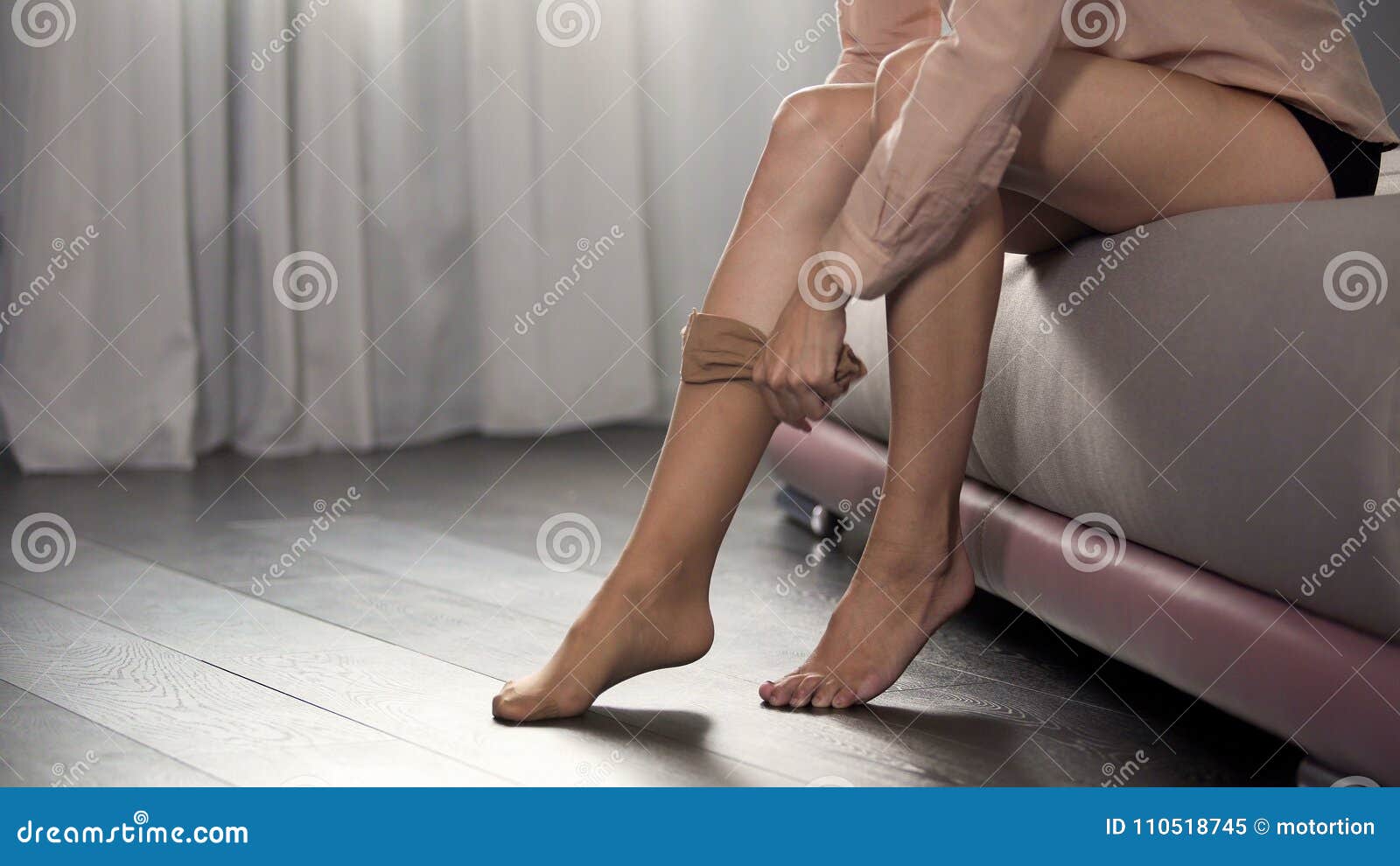 Girl Dressing Pantyhose on Her Slender Legs Sitting in Bedroom, Going To Work Stock Image