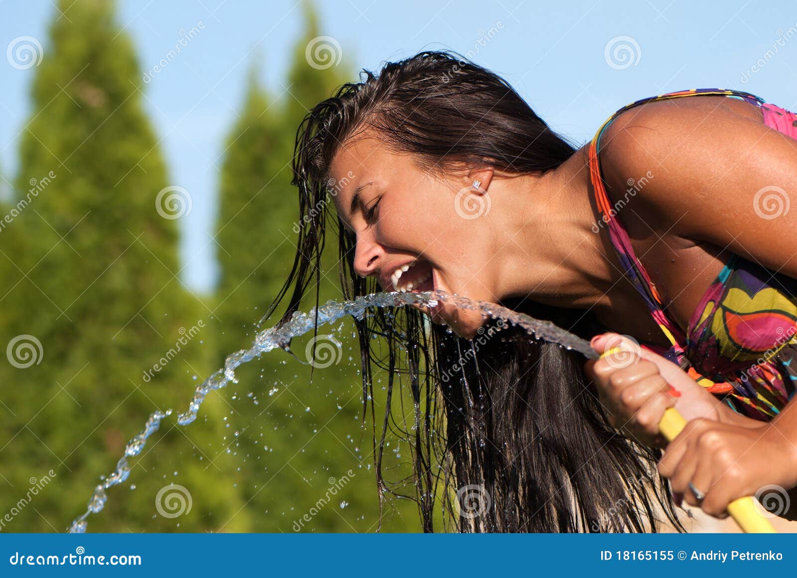 girl drinking water from a hose