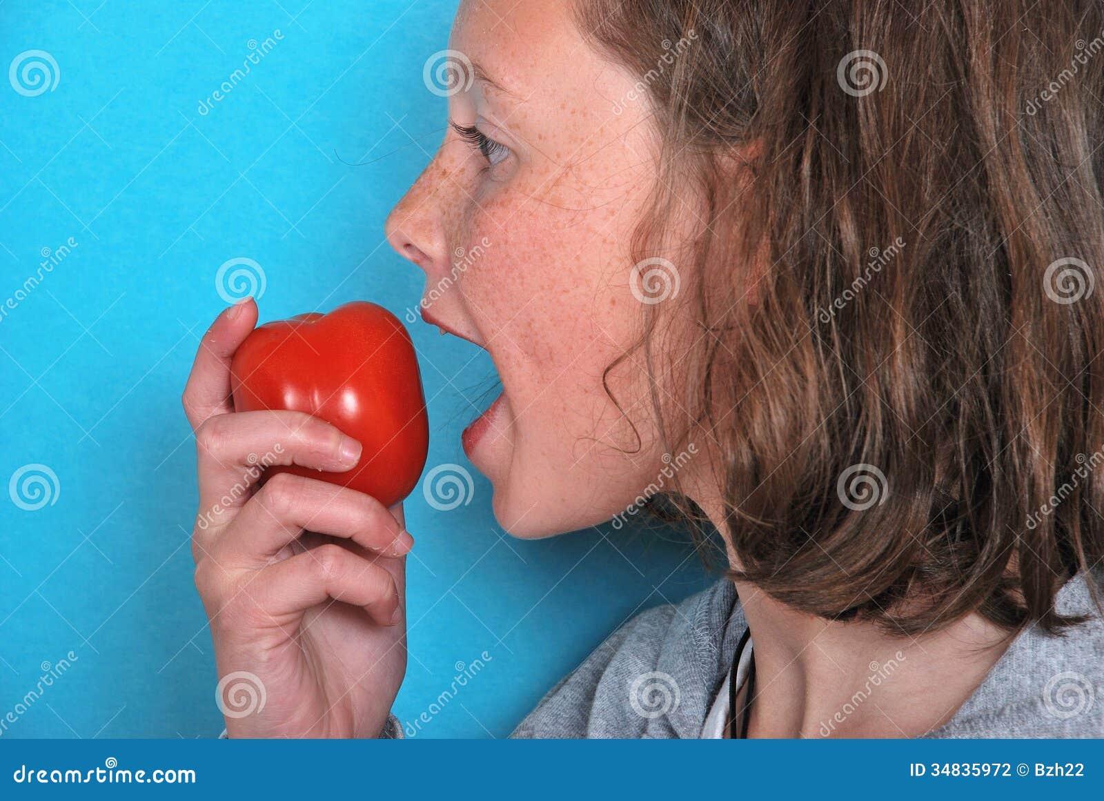 Girl eating a tomato stock photo. Image of blond, joyful 34835972