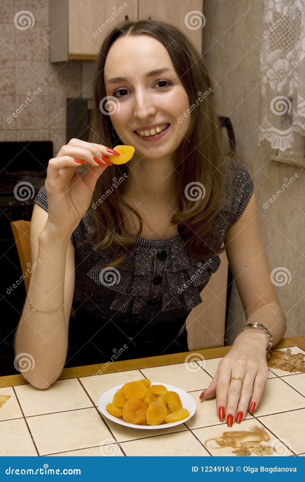 Girl eats dried apricots stock image. Image of femininity 12249163