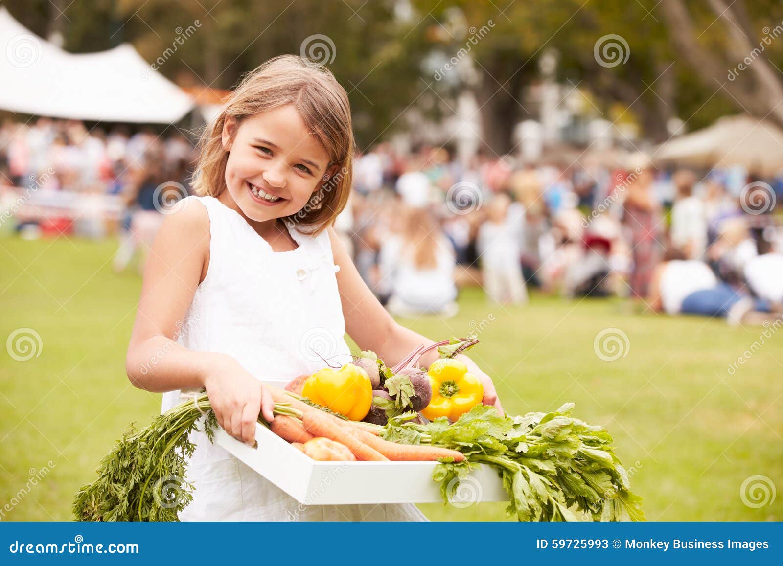 girl with fresh produce bought at outdoor farmers market