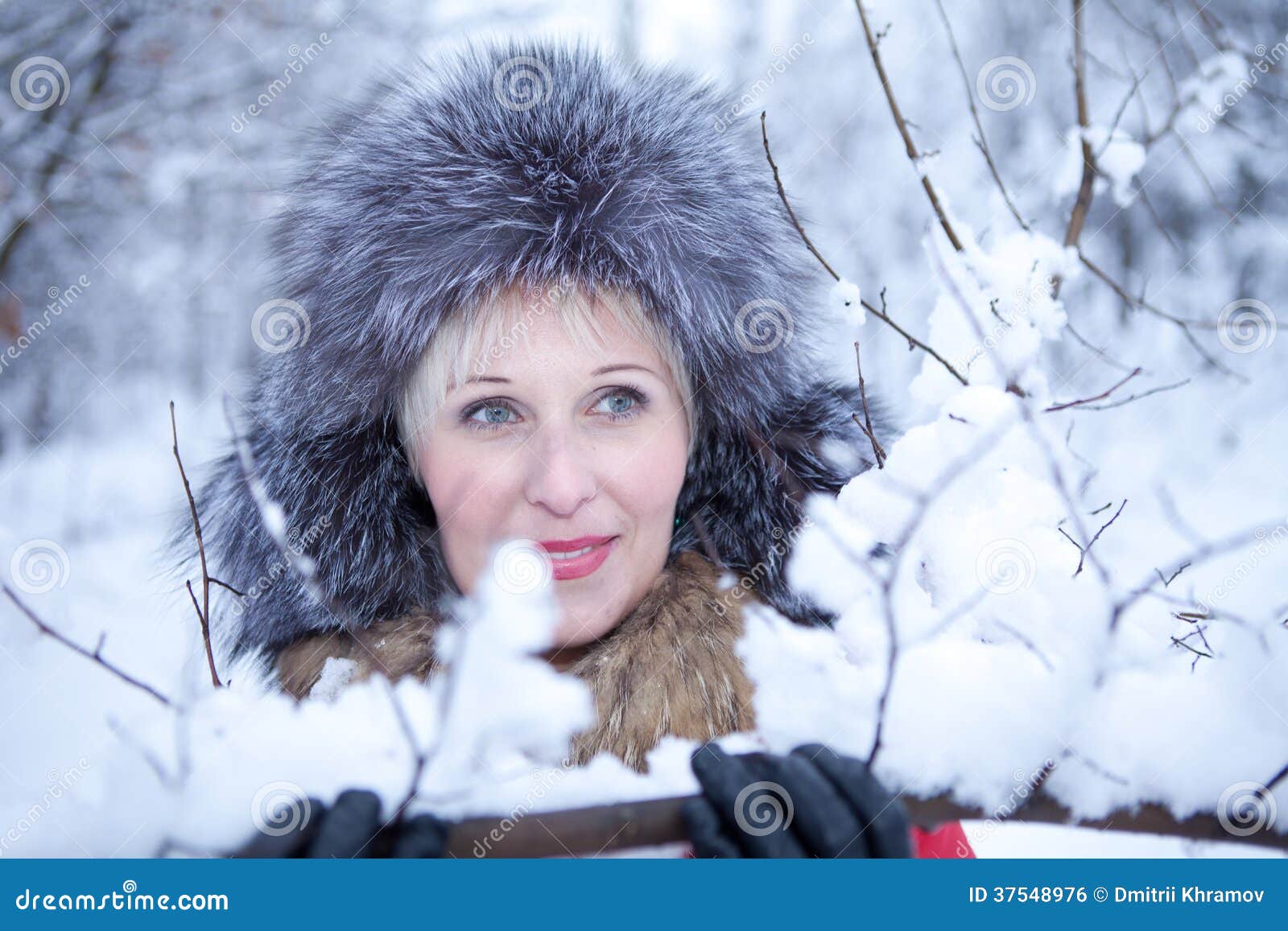 Vertical shot of a beautiful Caucasian woman in jeans and winter coat posing  on the snow Stock Photo by wirestock
