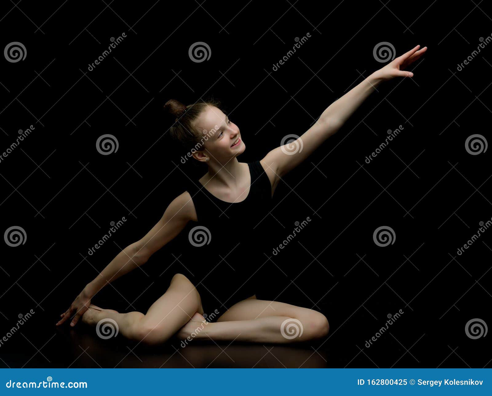 Girl Gymnast in the Studio on a Black Background Performs Gymnas Stock ...