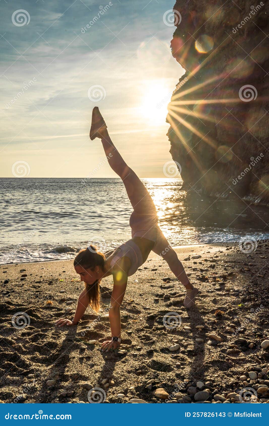 Girl Gymnast is Training on the Beach by the Sea Sunset. Does Twine ...