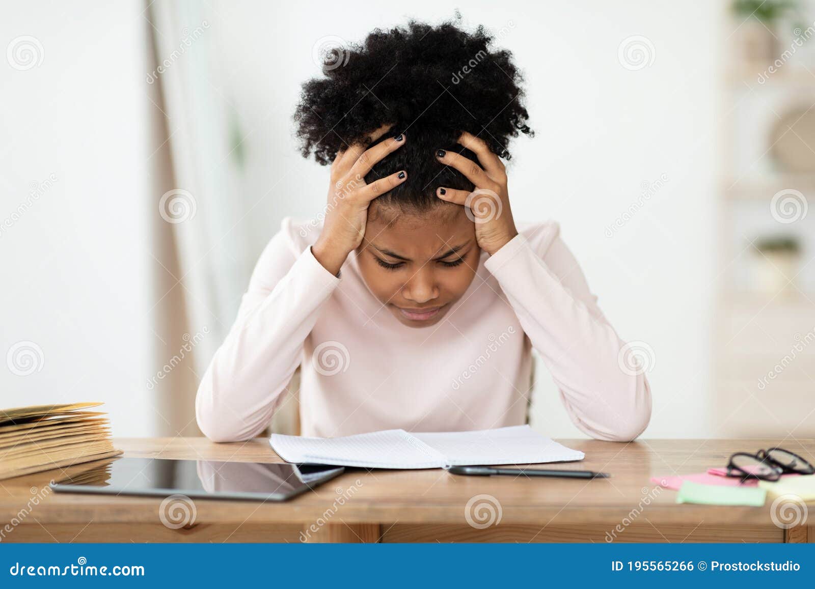 girl having hard time doing homework online, sitting depressed indoors