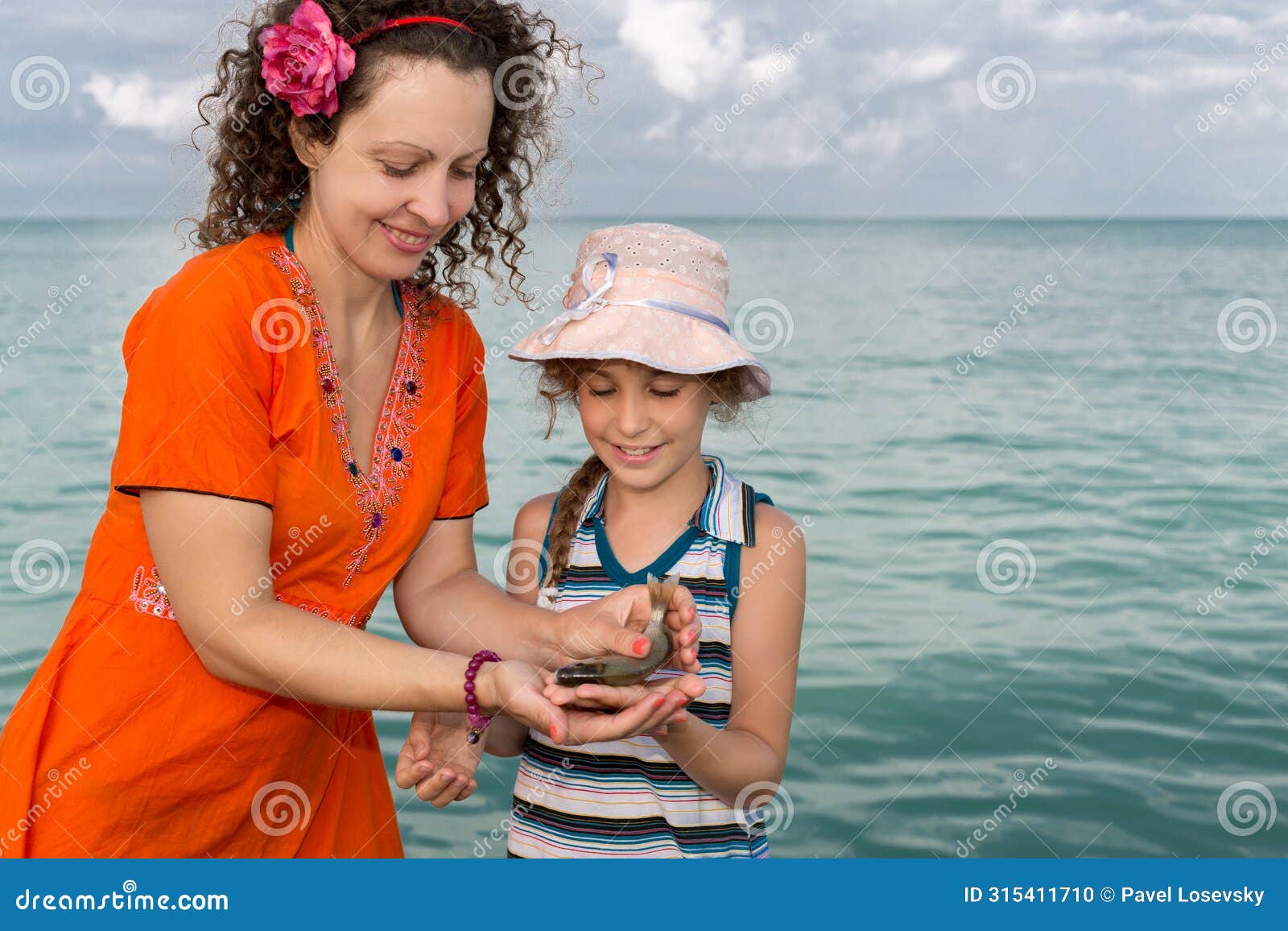 girl with her mother holding freshly caught