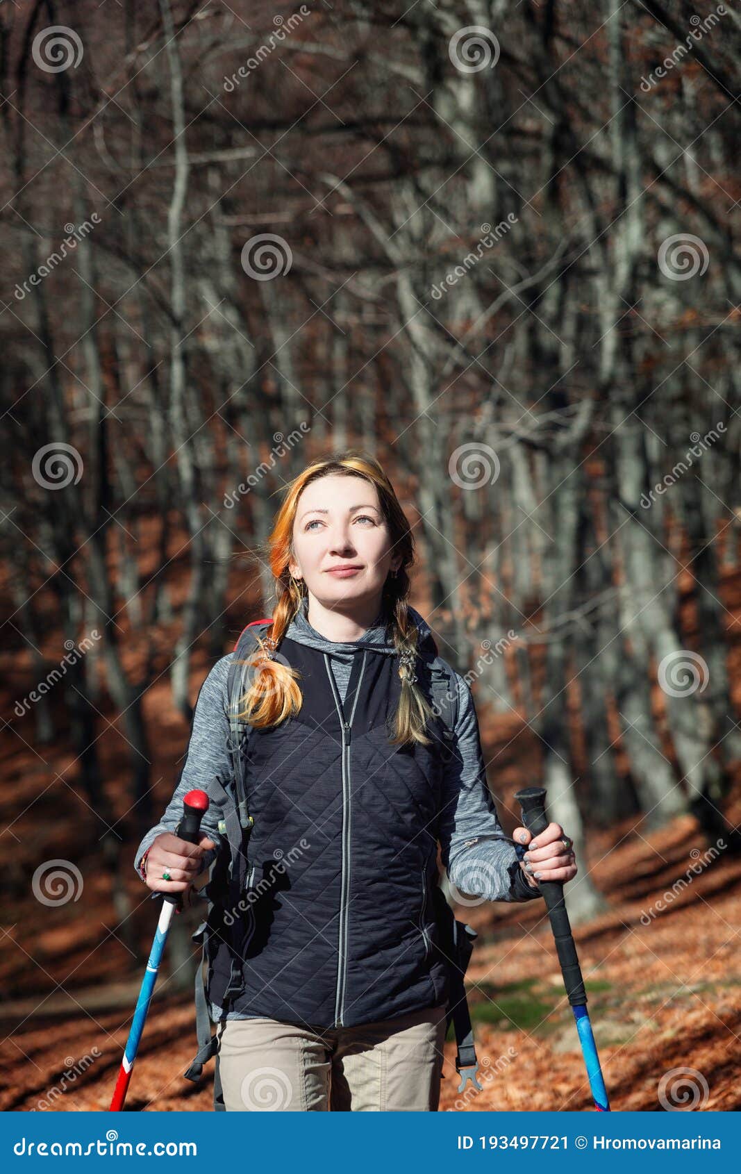 A Girl in Hiking Clothes with Trekking Poles Walks in the