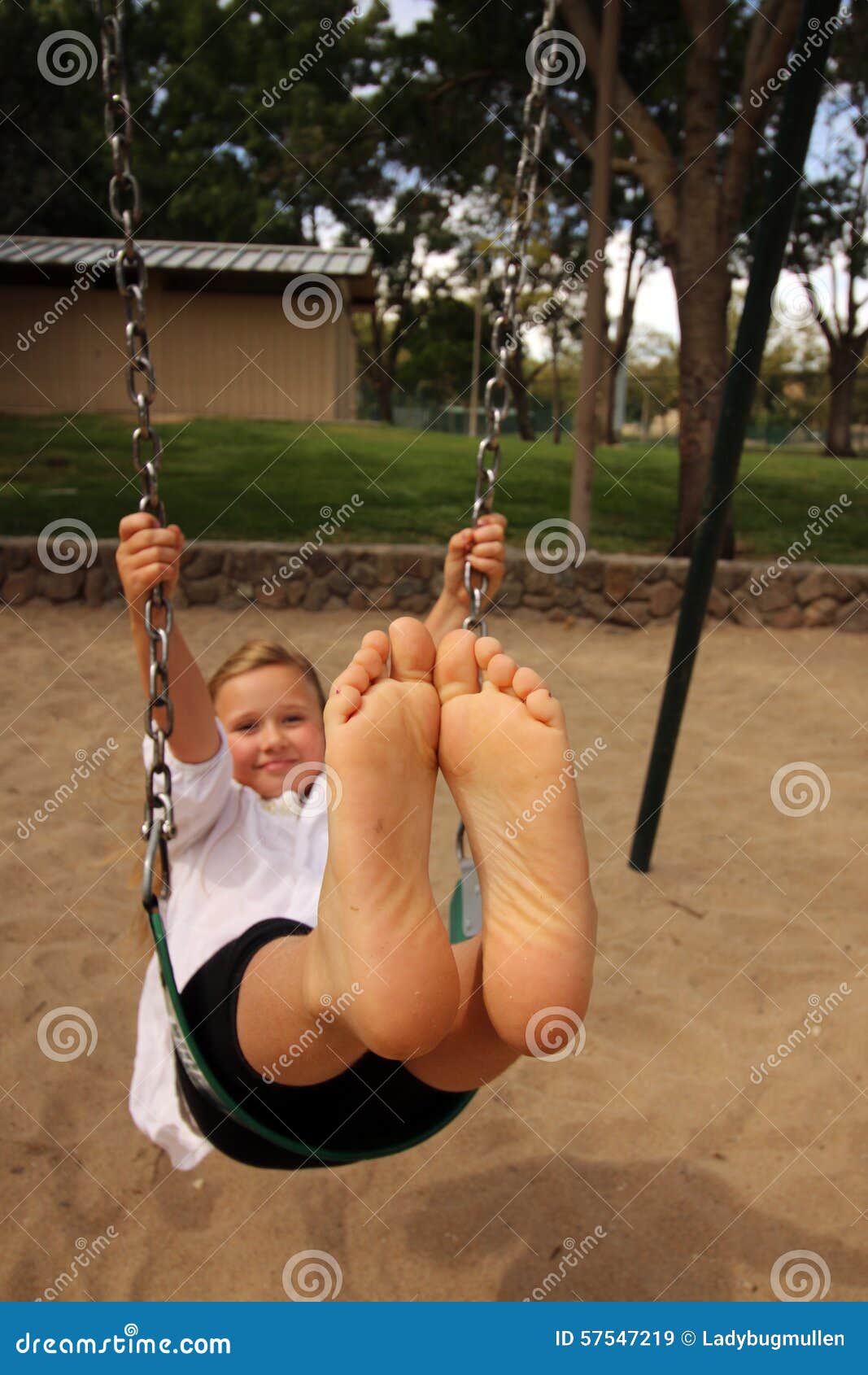 girl with her feet together in the air swinging