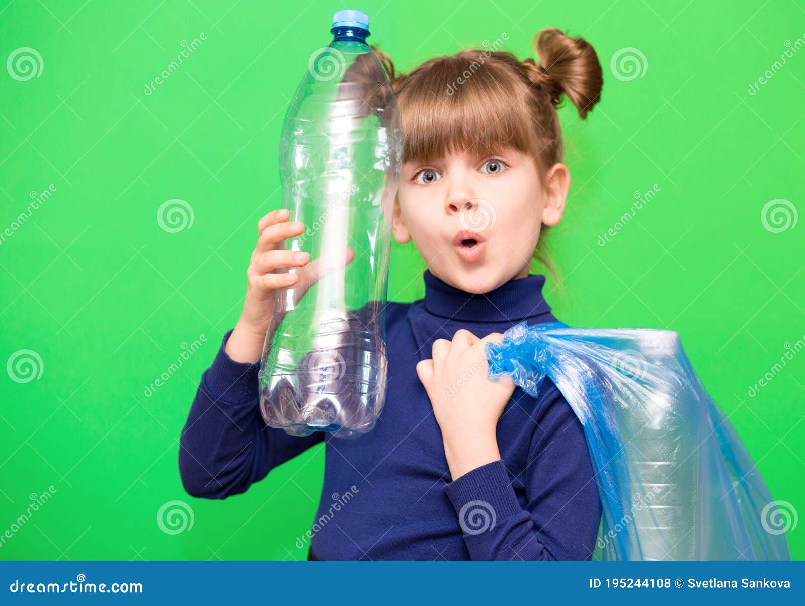 girl hold trash bag and plastic bottle and shows interest in environmental issues  on green background. child accustomed