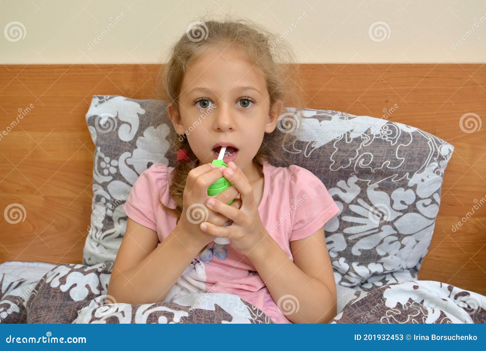 the girl holds a spray and irrigates their throats while sitting in bed. self-treatment