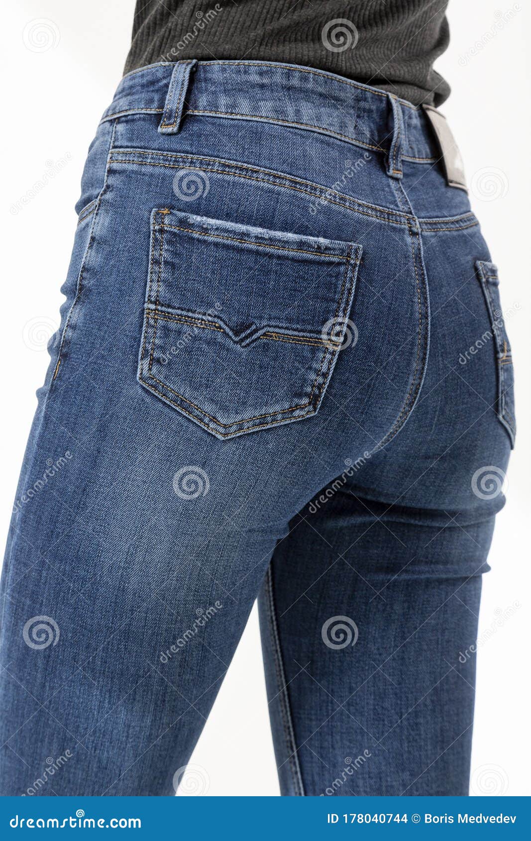 Girl In Jeans Shows Jeans Back Pockets On A White Background Close-up ...