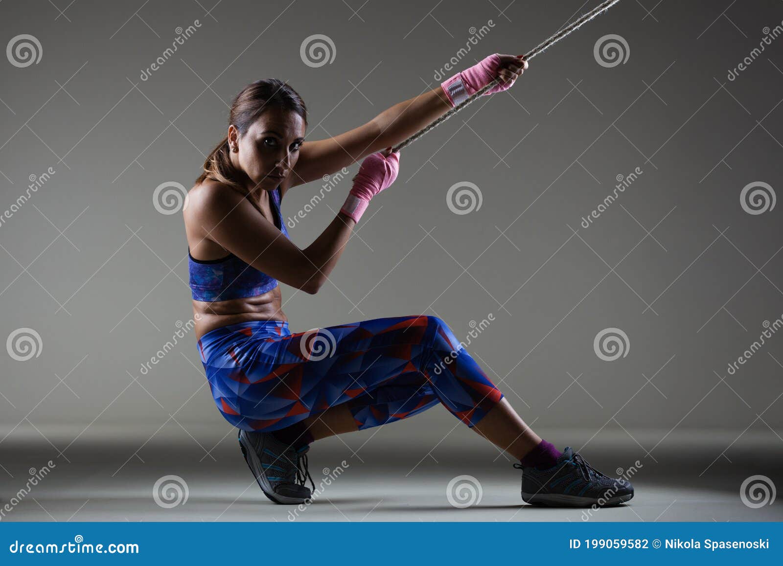 Girl Kickboxer Pulling a Chain with Pink Hand Wraps Stock Photo Image