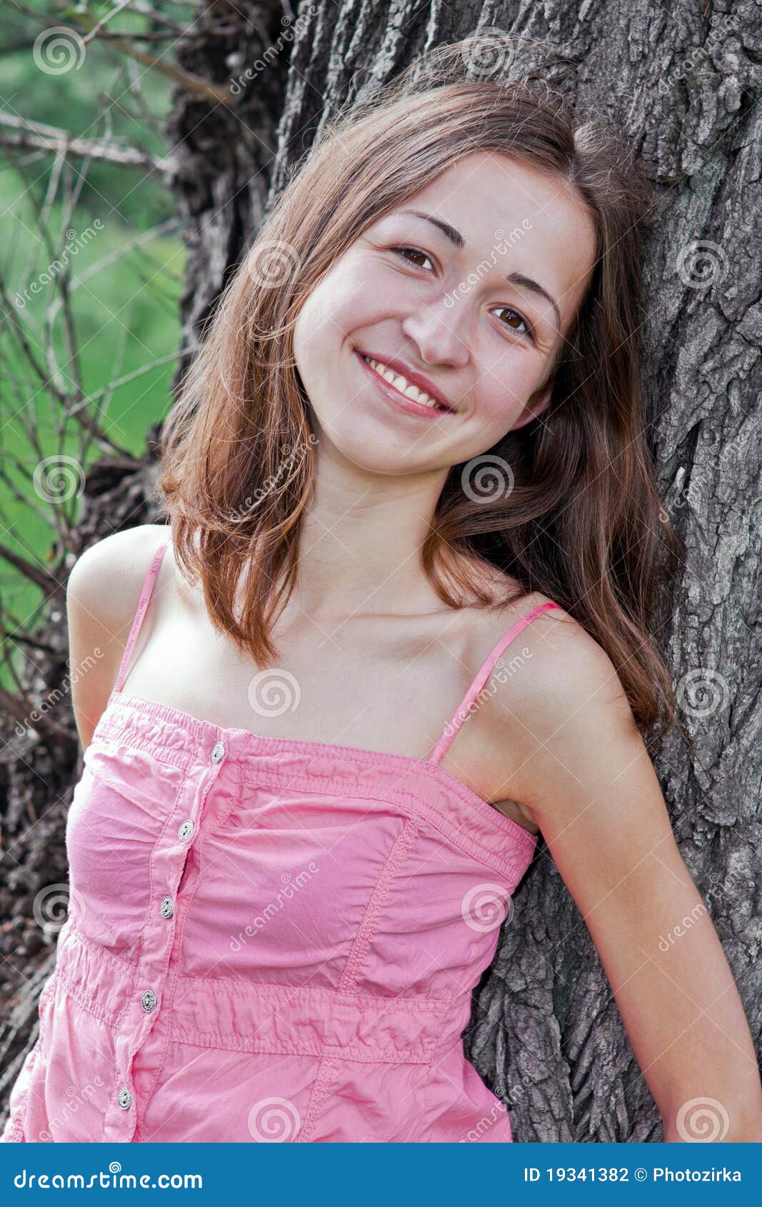Girl leaning on a tree stock photo. 