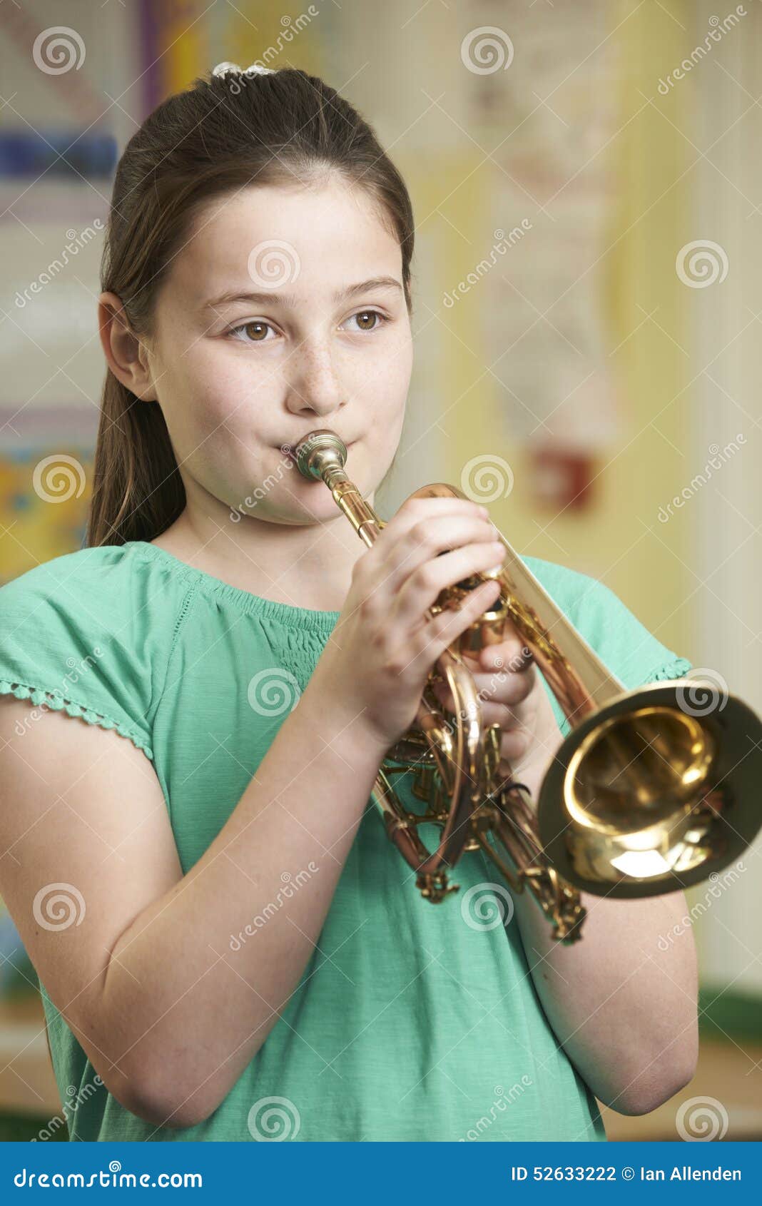 Girl Learning To Play Trumpet in School Music Lesson Stock Photo