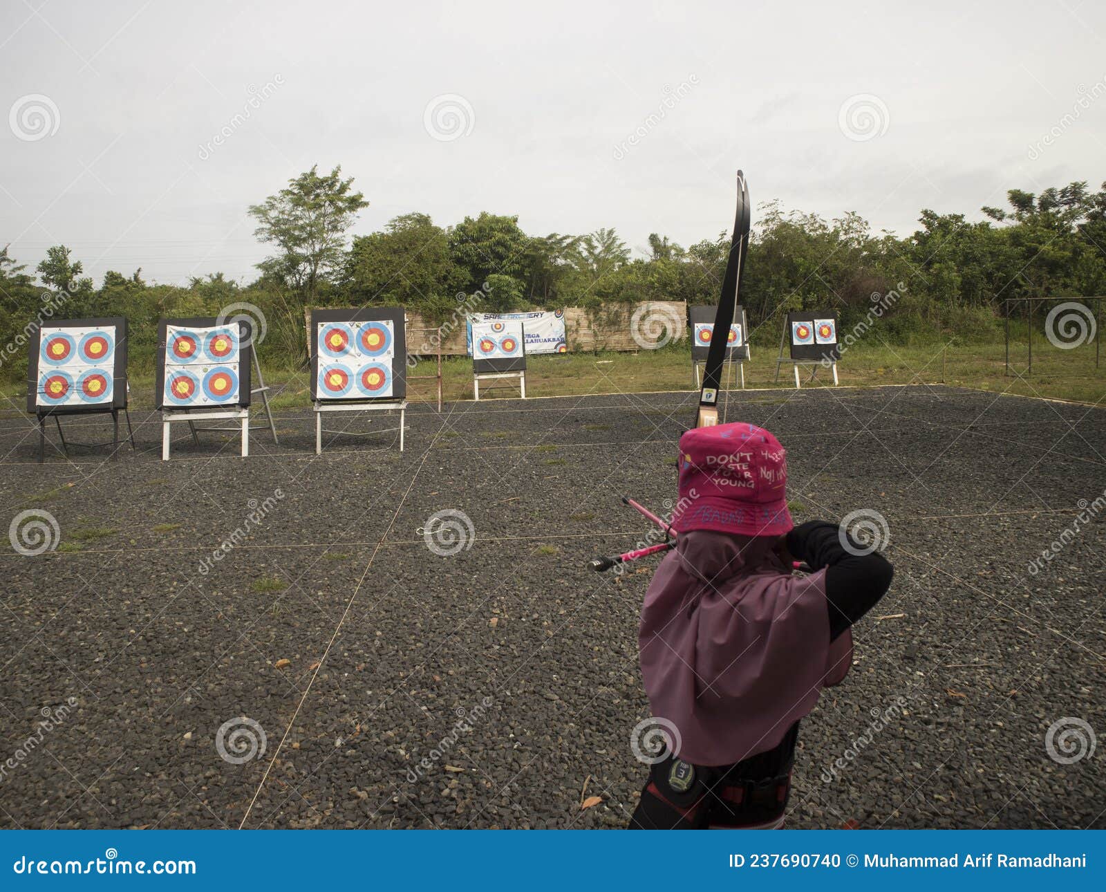 A Girl is Located in Archery. Use a Pink Hat and Raise a Bow Stock