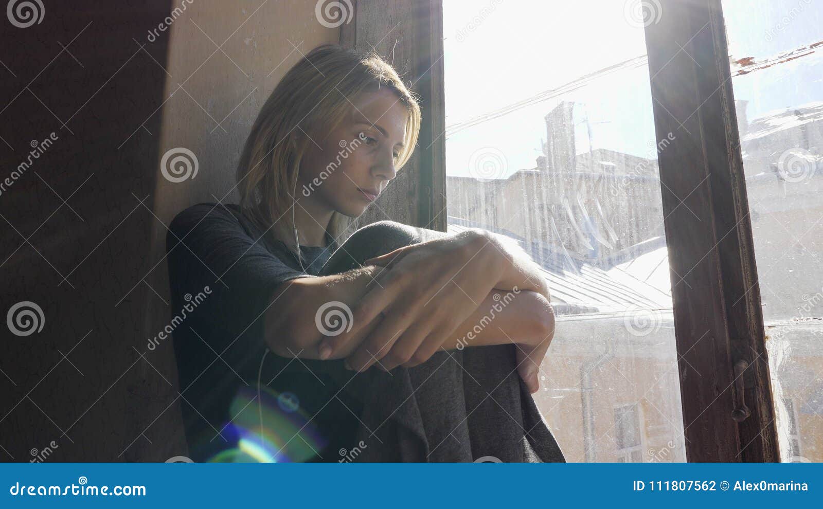 Girl Looks Very Sad while Listening Music on Headphones by the ...