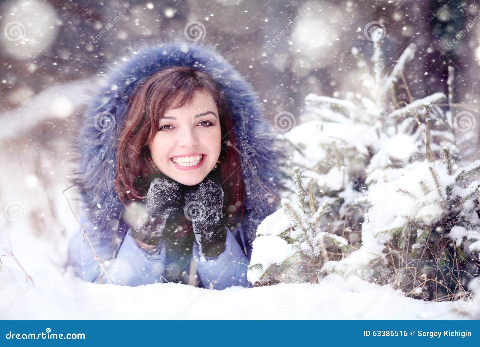 Girl lying in the snow stock photo. Image of pretty, smile - 63386516