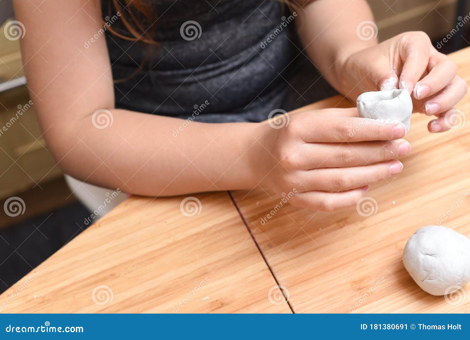 girl making pottery models with white clay at home