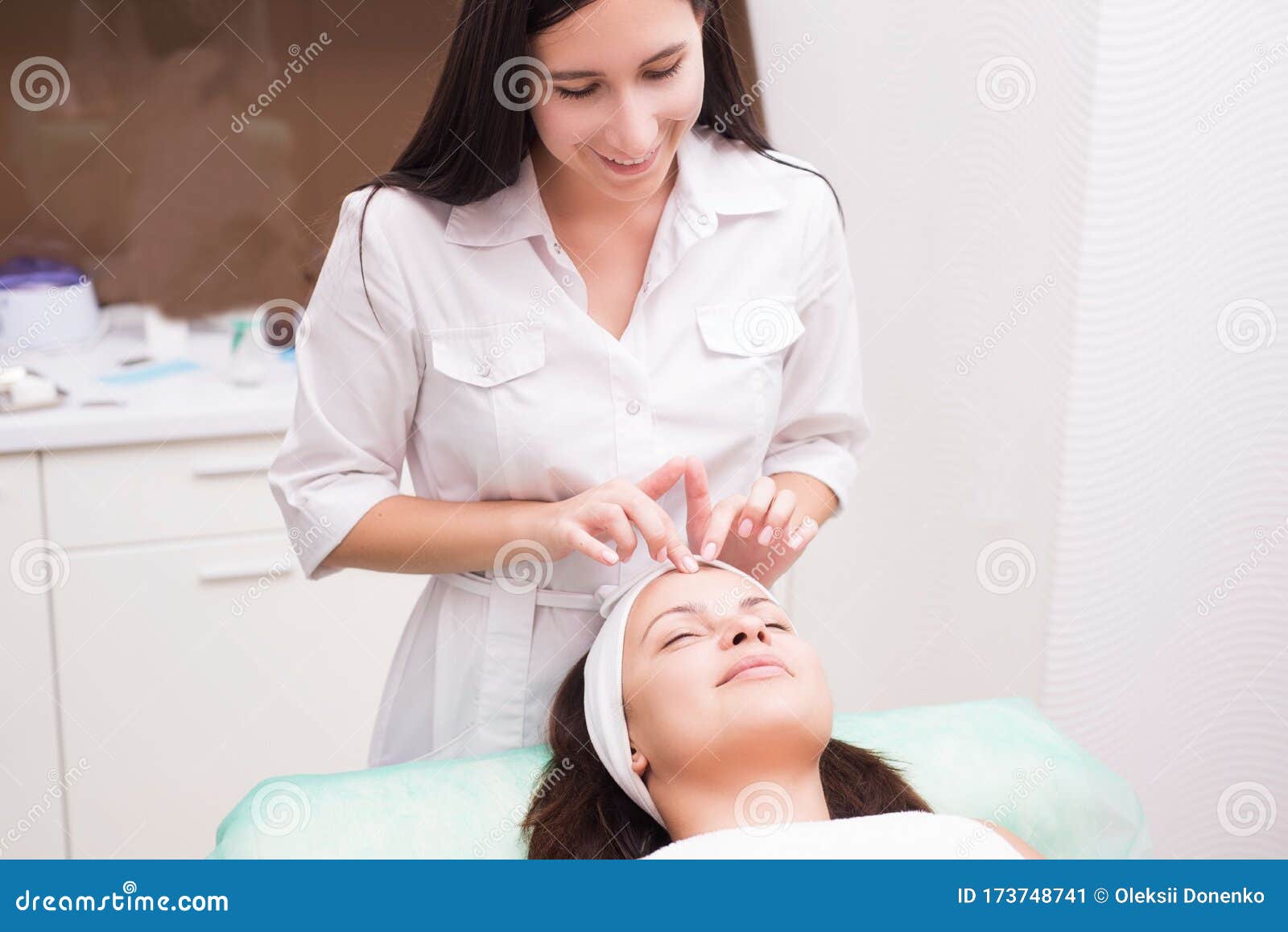 Girl Massage Therapist Does Facial Massage With A Beautiful Woman Hands Are Closing Stock Image