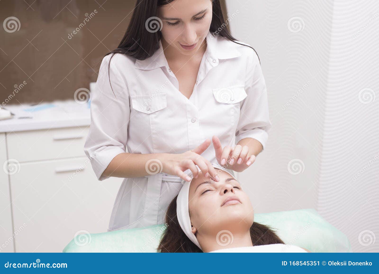 Girl Massage Therapist Does Facial Massage With A Beautiful Woman Hands Are Closing Stock Image