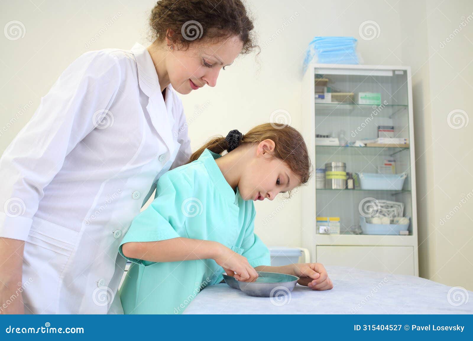 girl and medical worker looking at the contents of