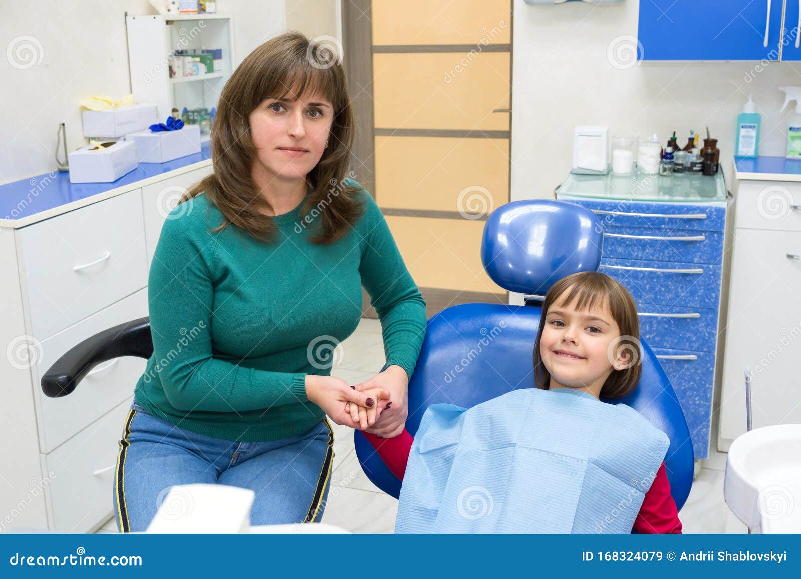 a girl and a mother in in a dentistÃ¢â¬â¢s office