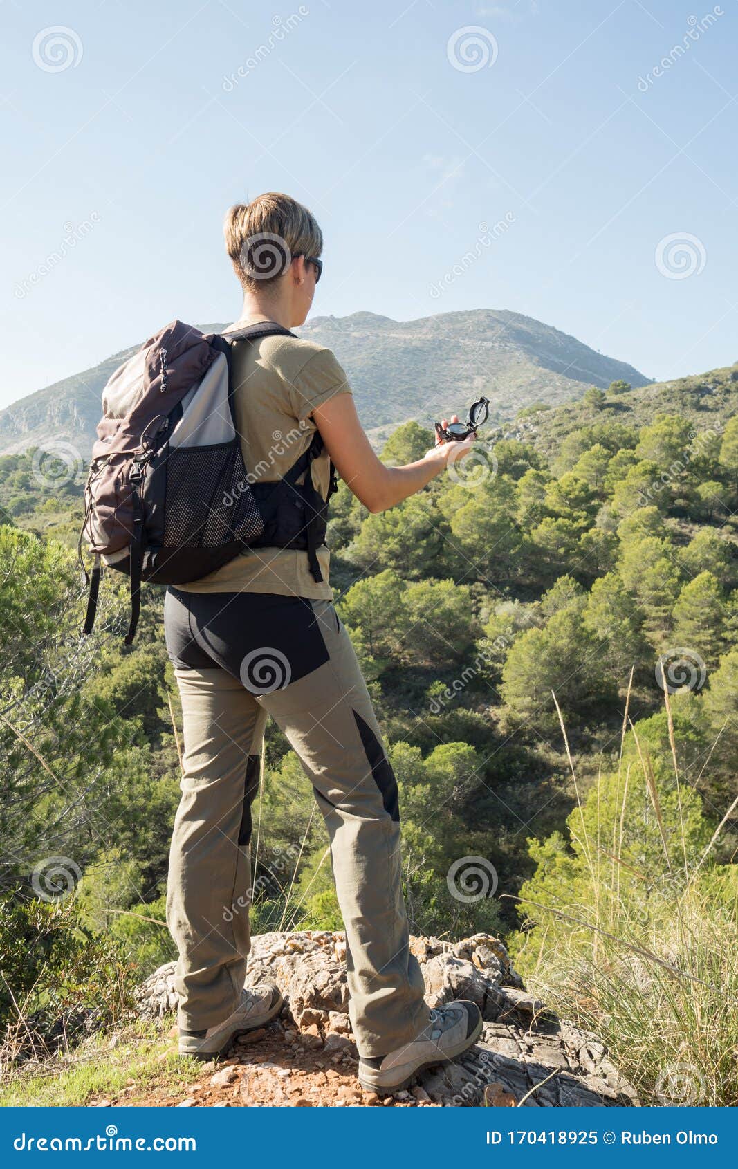 Girl Orienting with a Compass while Hiking in the Mountains with a