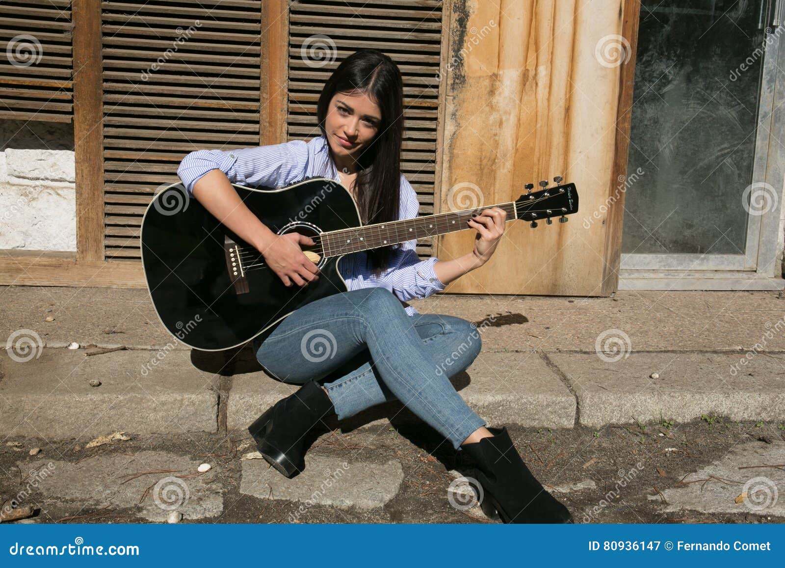 Premium Photo | Young man with a guitar on the background of a brick wall