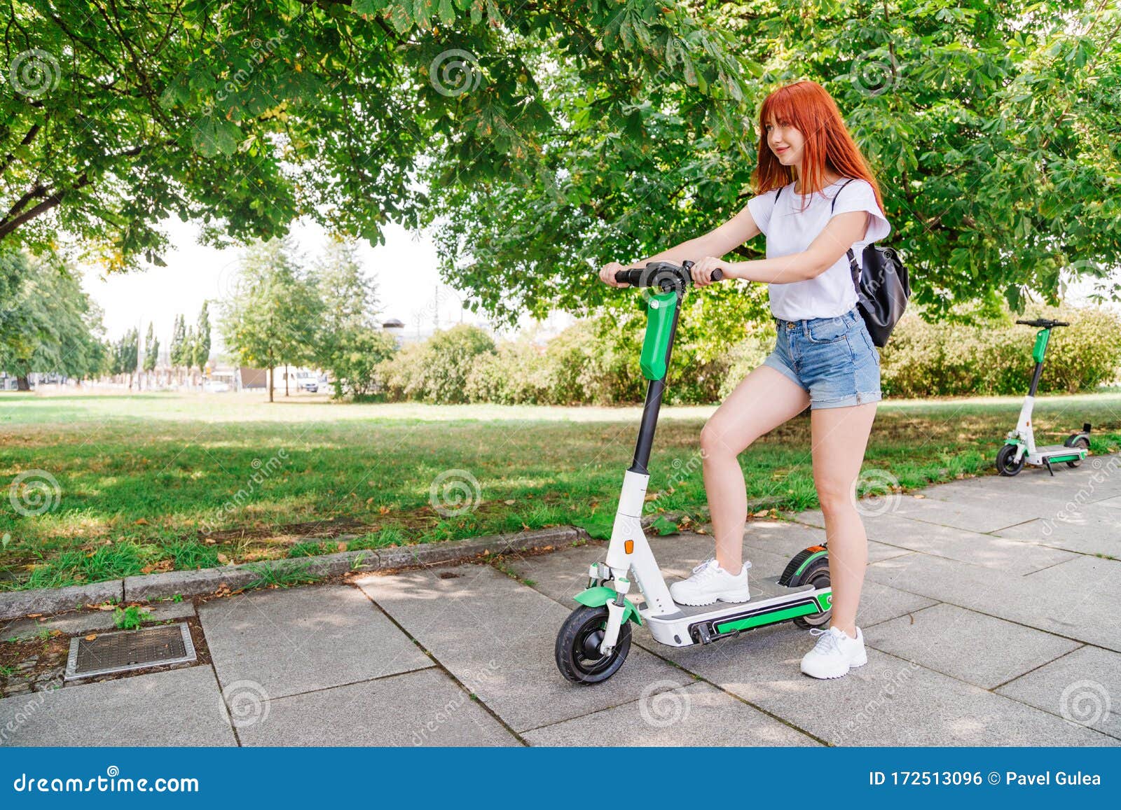 Girl Pushes Off Ground To Start Riding Scooter Stock Photo - Image of ...