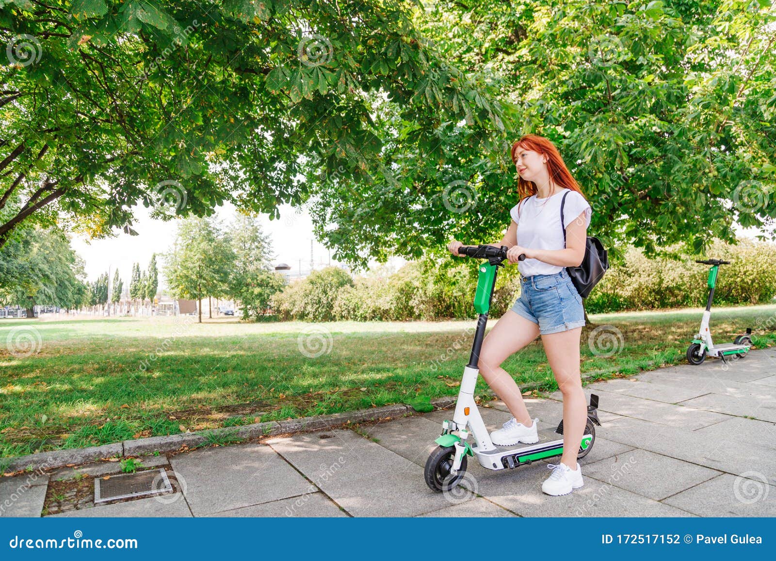 Girl Pushes Off Ground To Start Riding Scooter Stock Photo - Image of ...