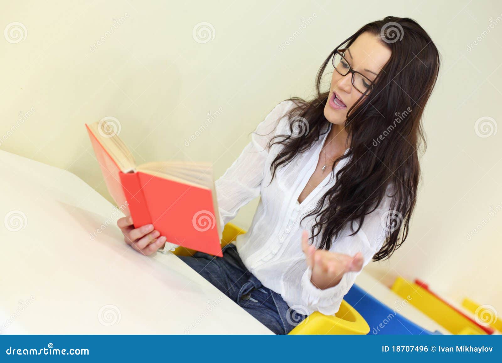 Девушка читает на вибраторе. Читающая девушка в белом и желтом. Девушка с книгой в руках. Девушка с книгой вид с боку. Женщина с учебниками на коленках.
