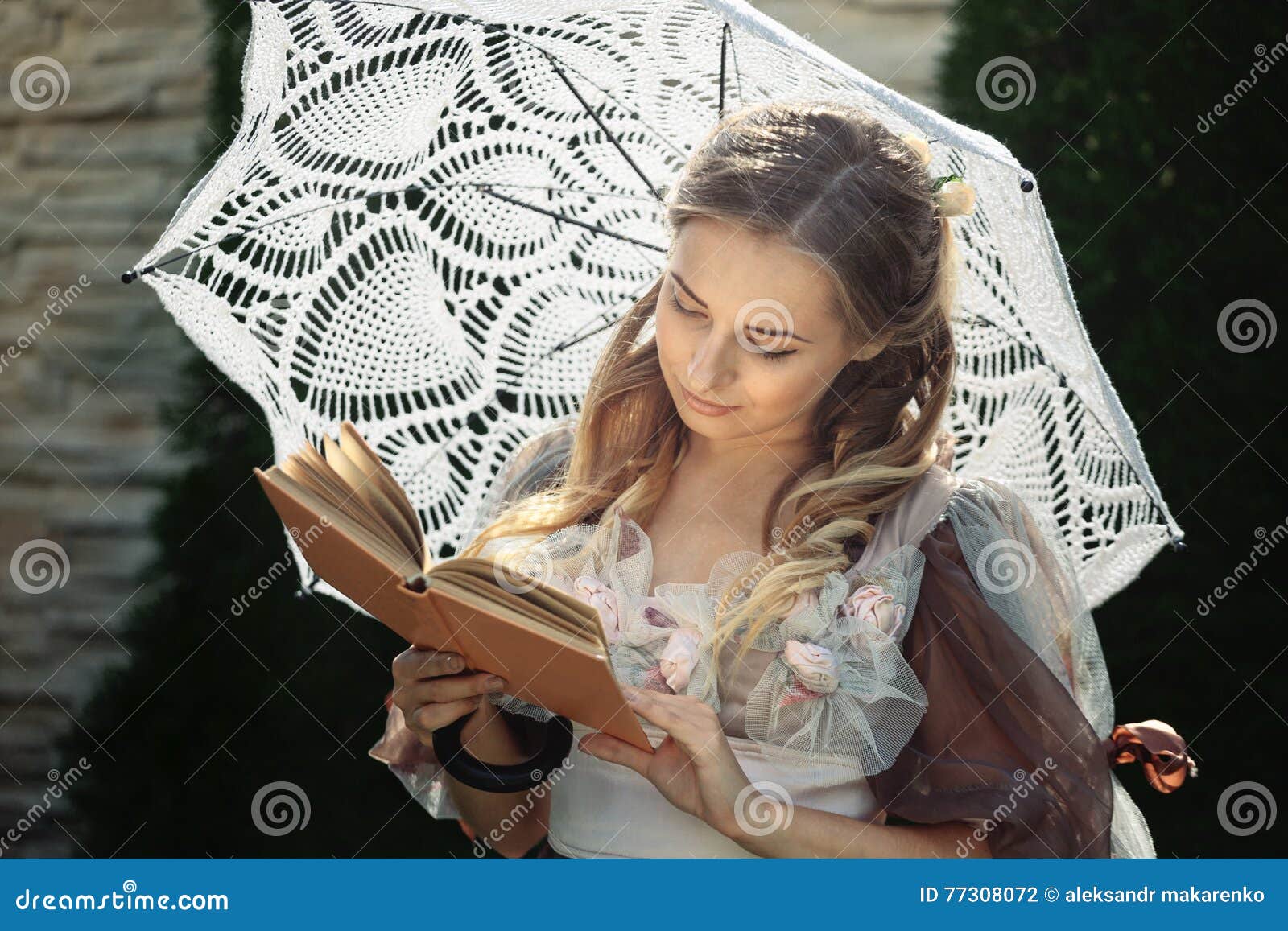 Girl Reading a Book while Standing Under an Umbrella Stock Photo