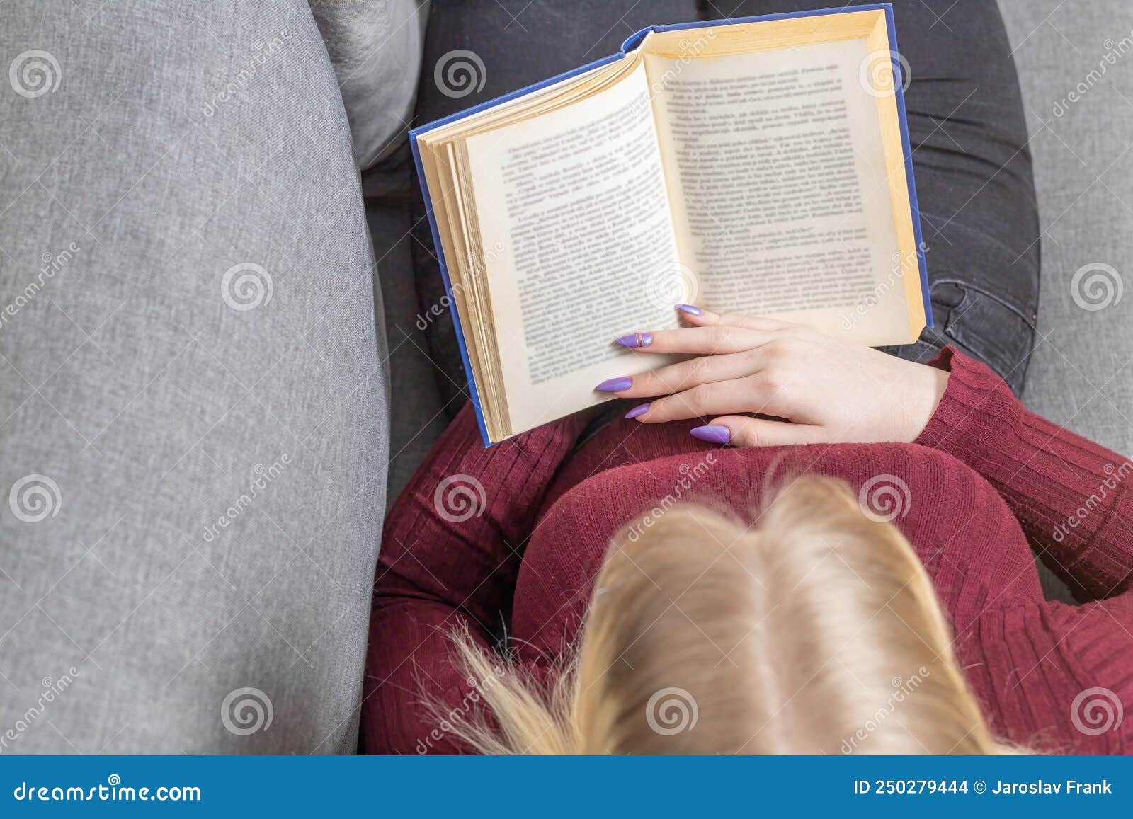 Girl is Reading a Book while Upside Down on Sofa. Horizontally Stock Photo Image of hair