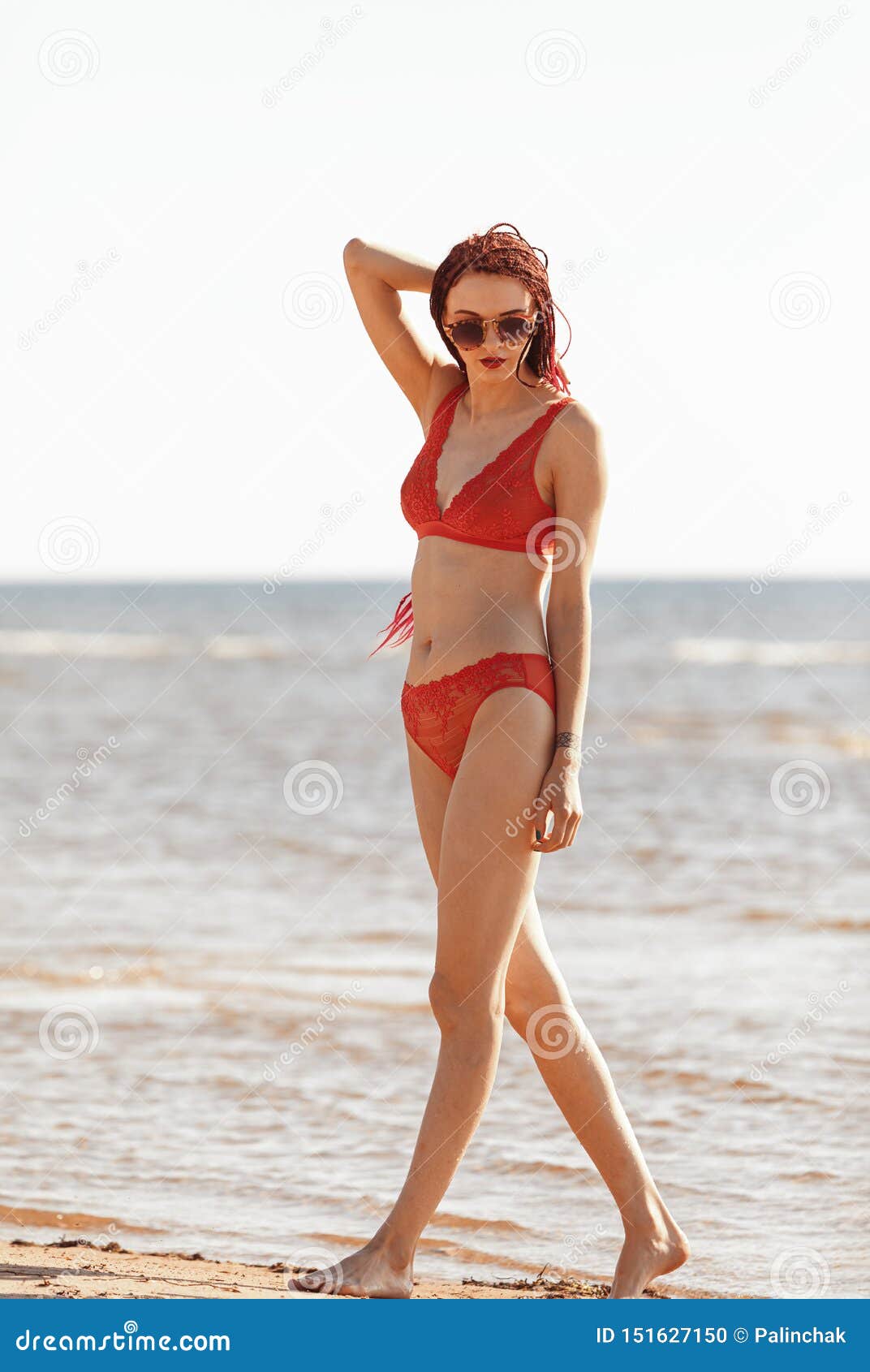 Girl in a Red Bathing Suit on the Beach Stock Photo