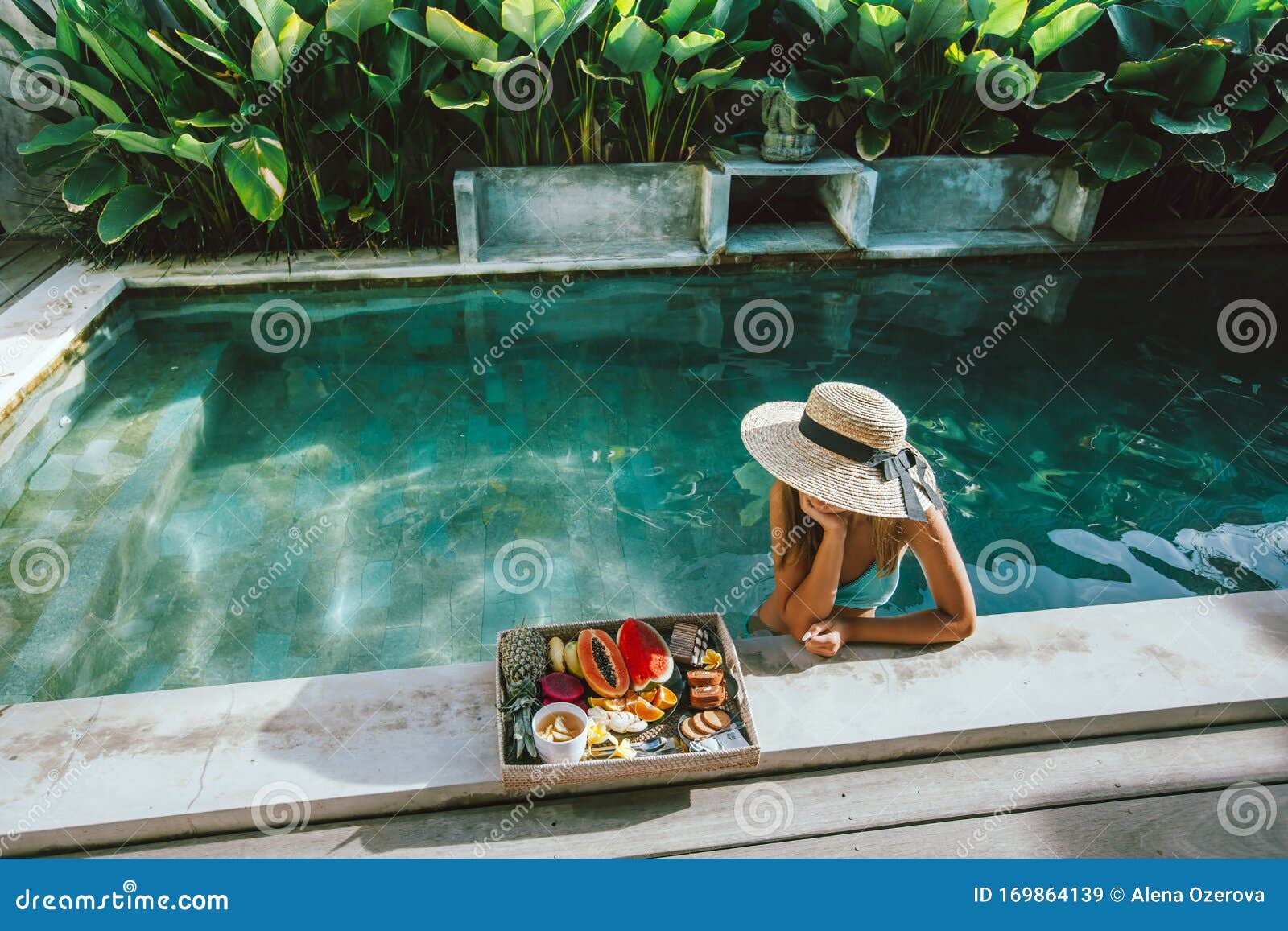 girl relaxing and eating fruits in the pool on luxury villa in bali