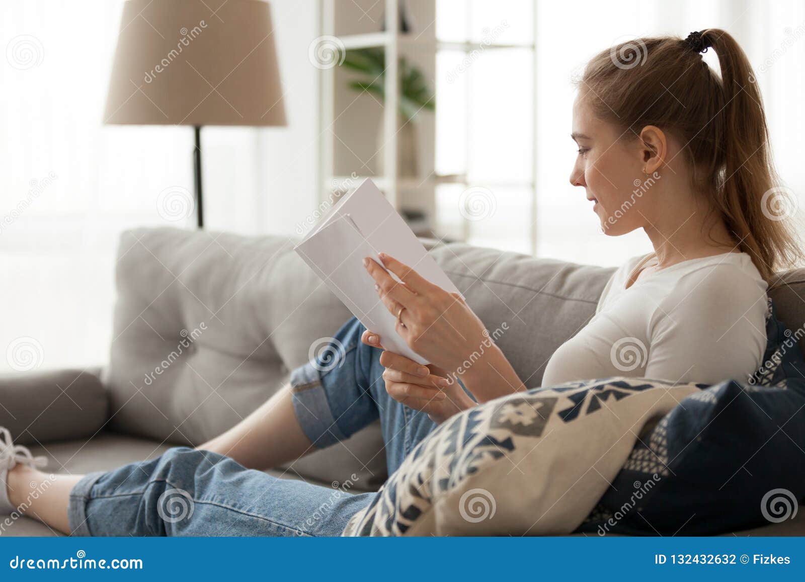 Girl Relaxing At Home Reading Book On Sofa Stock Photo Image Of