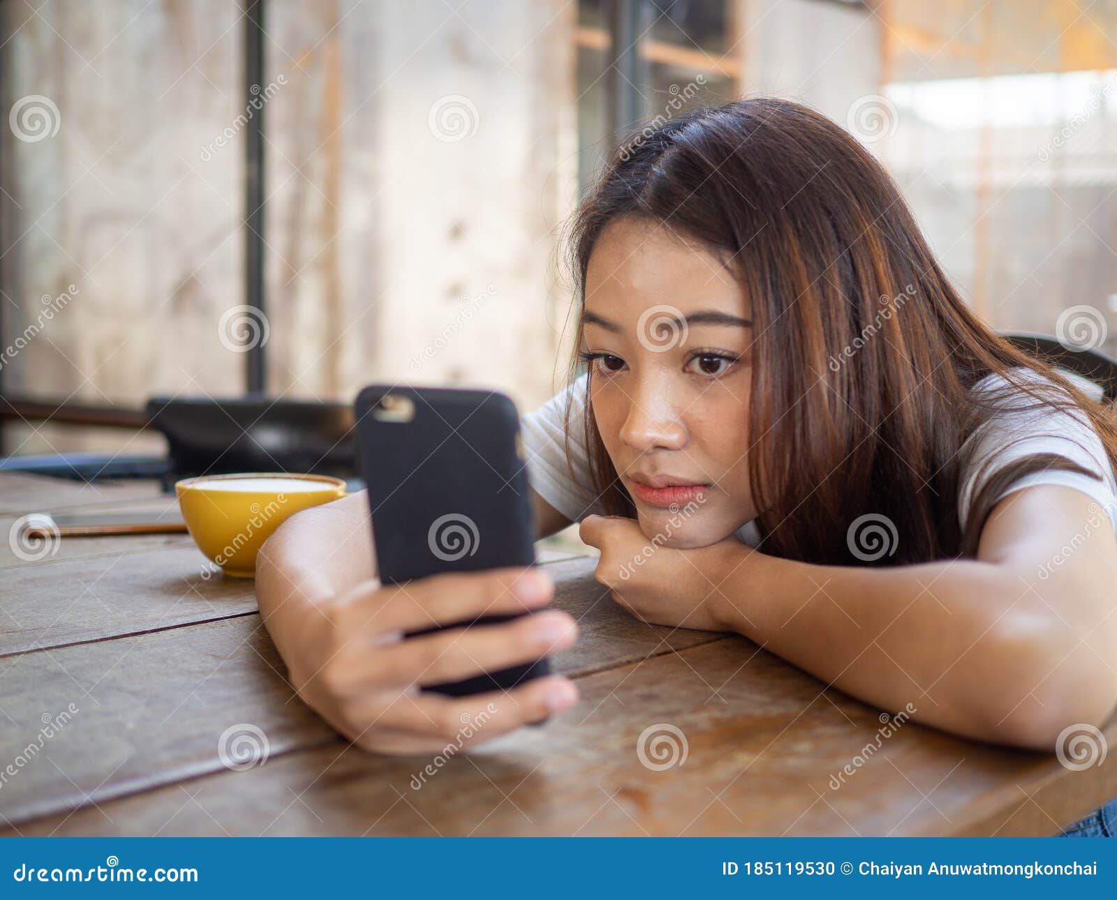 the girl sat staring at the phone in hand. a sad expression awaits the boyfriend calling