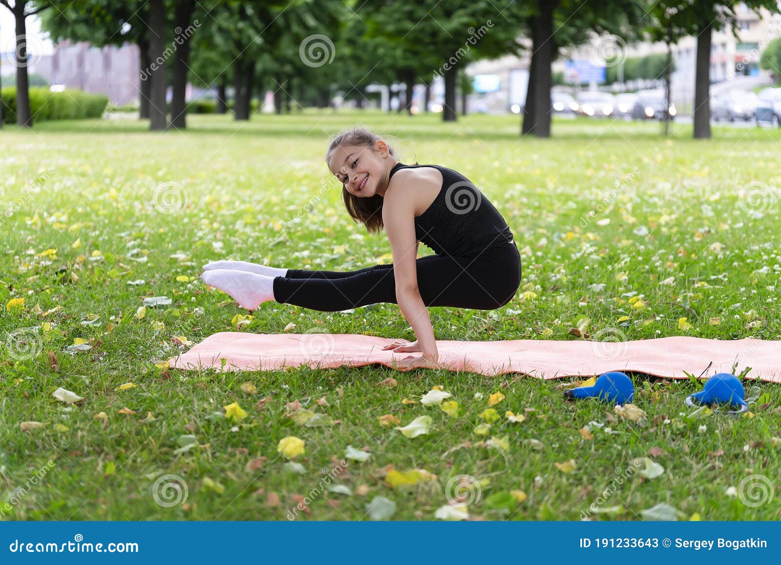A Girl of School Age Doing Gymnastics in a Park on the Grass Stock ...