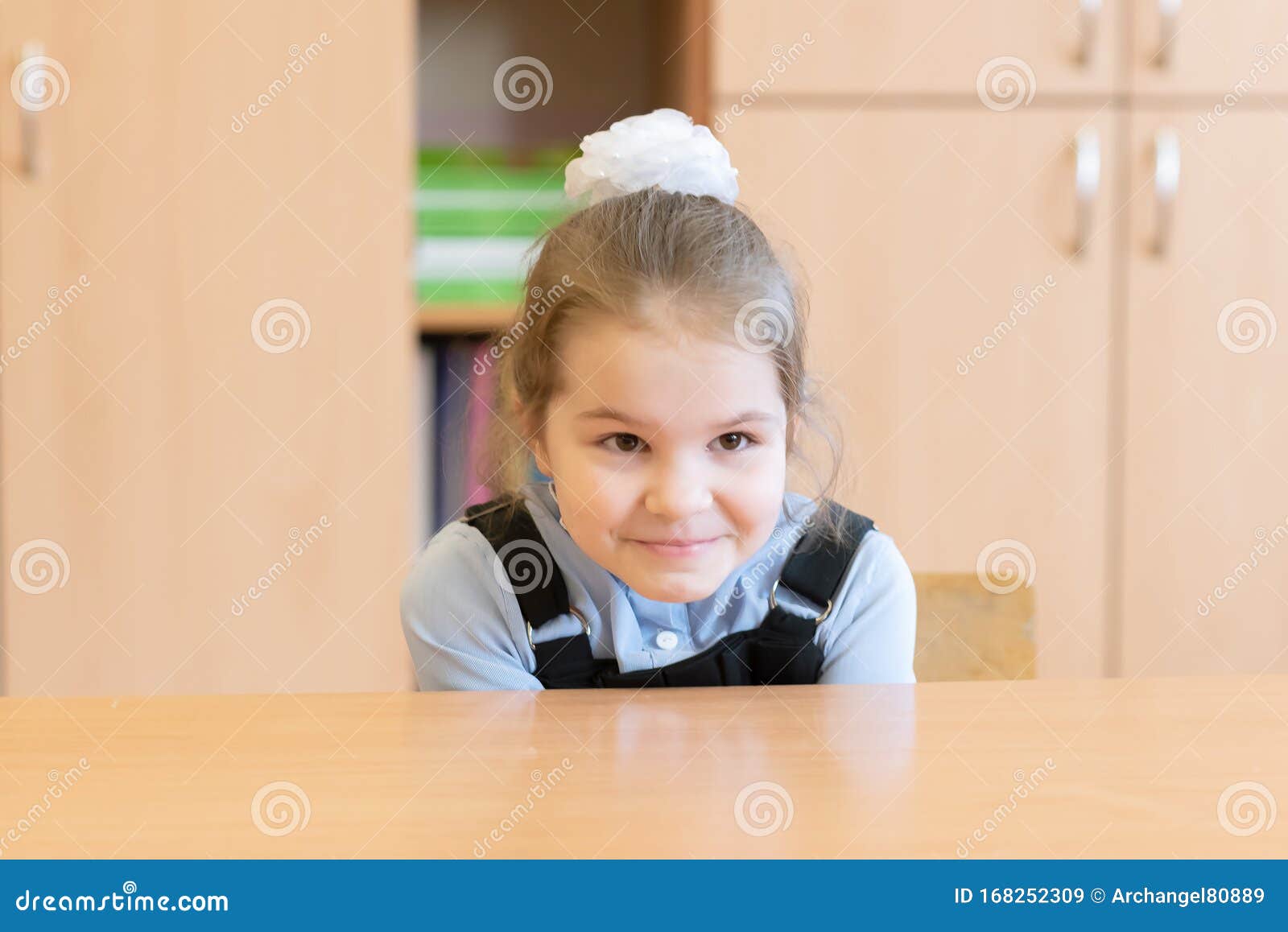 Girl Schoolgirl Is Trying To Hide Under The Desk Stock Image