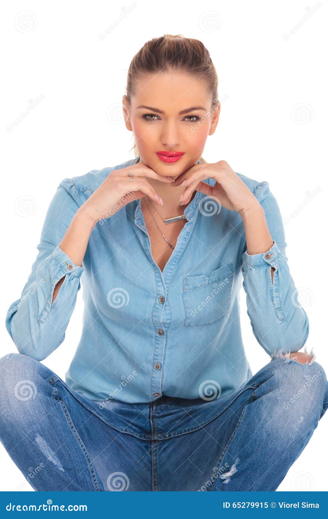 Girl Seated in Studio Background with Hands on Her Knees Touching Her ...