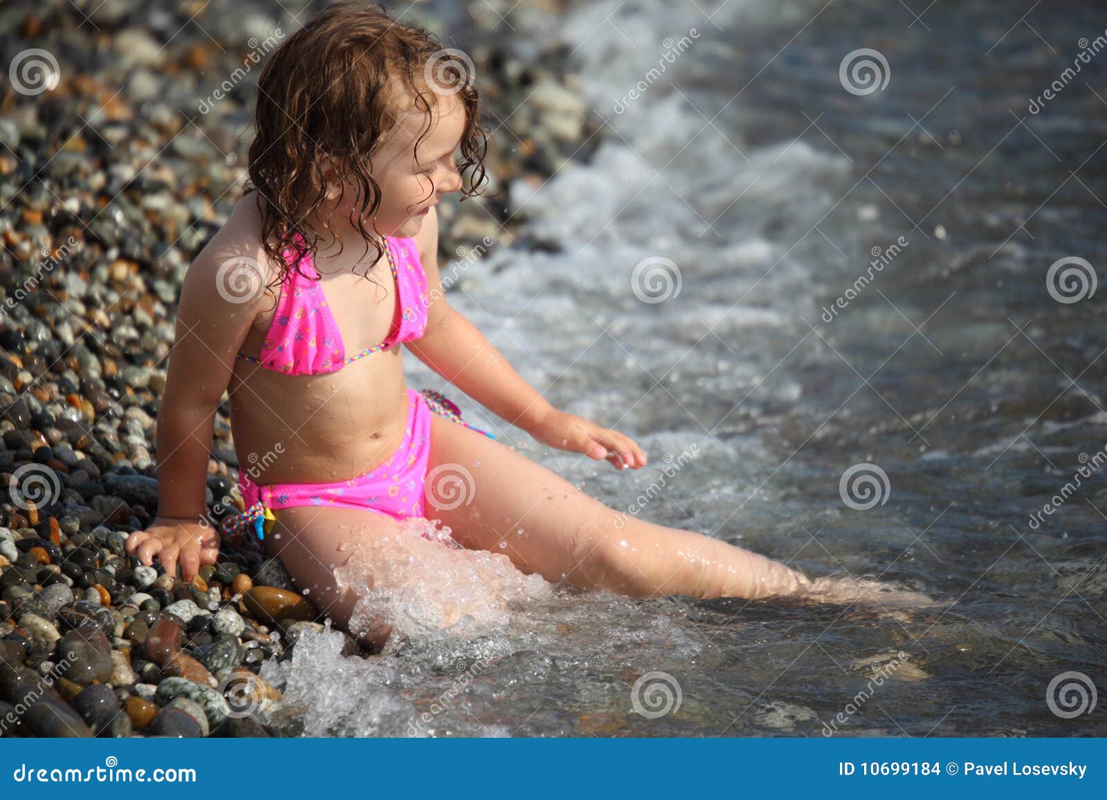 girl sits ashore in waves