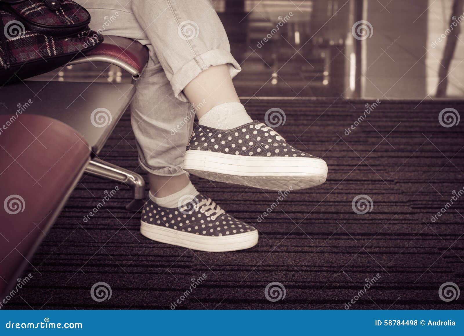 A Girl Sitting on a Chair. View of Feet in Sneakers and Jeans Stock ...