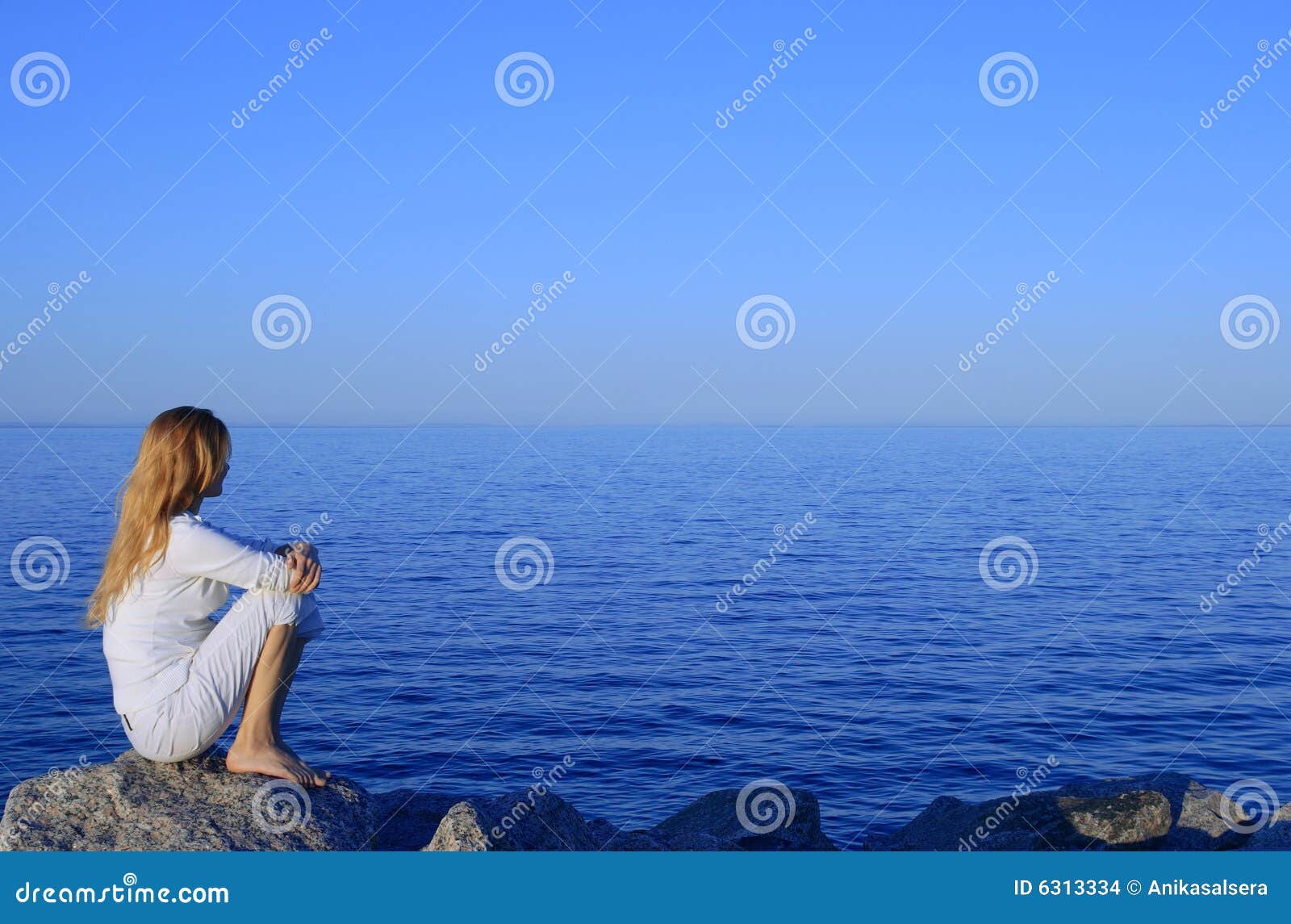 girl sitting on the rock by the peaceful sea