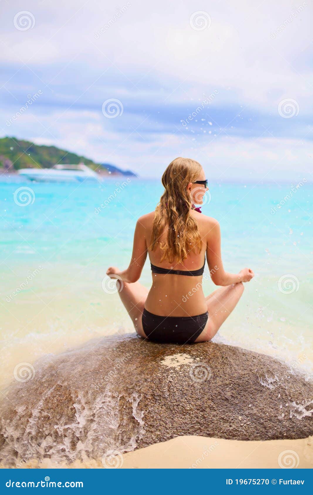 girl sitting on stone backward near sea