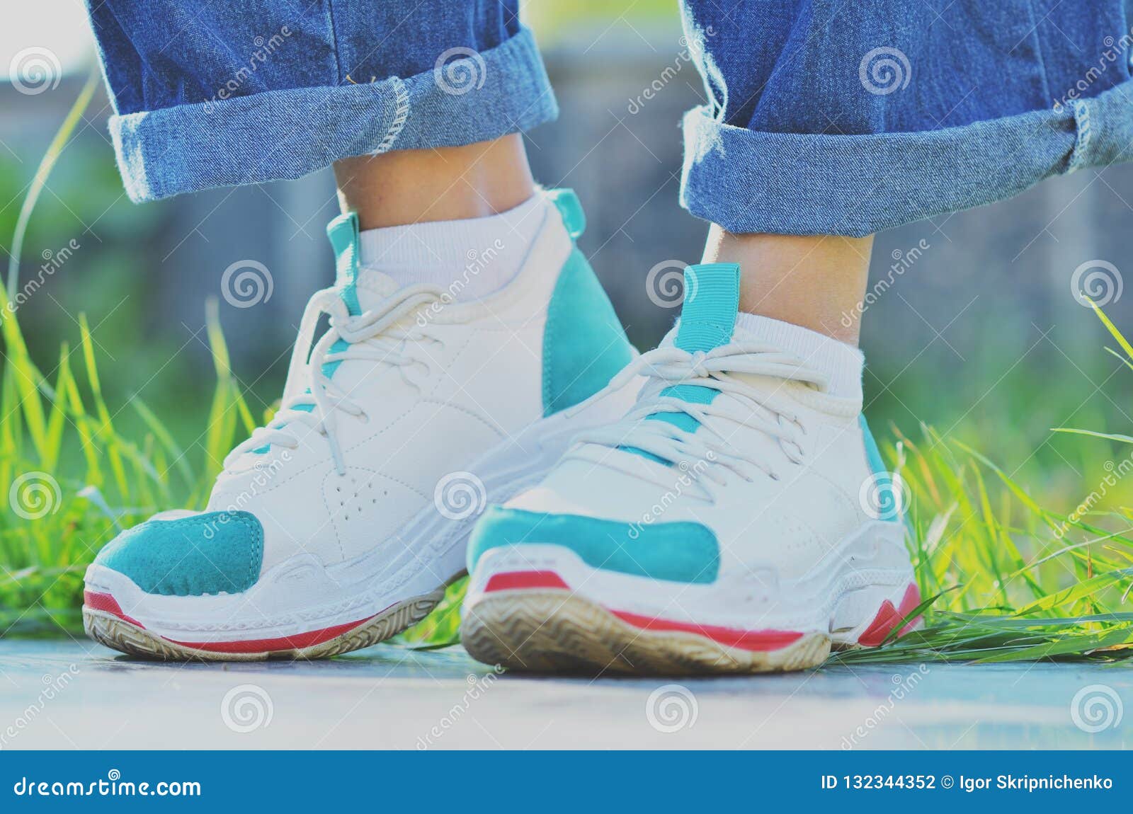 Girl in Sneakers Standing Near the Green Grass on a Sunny Day Stock ...