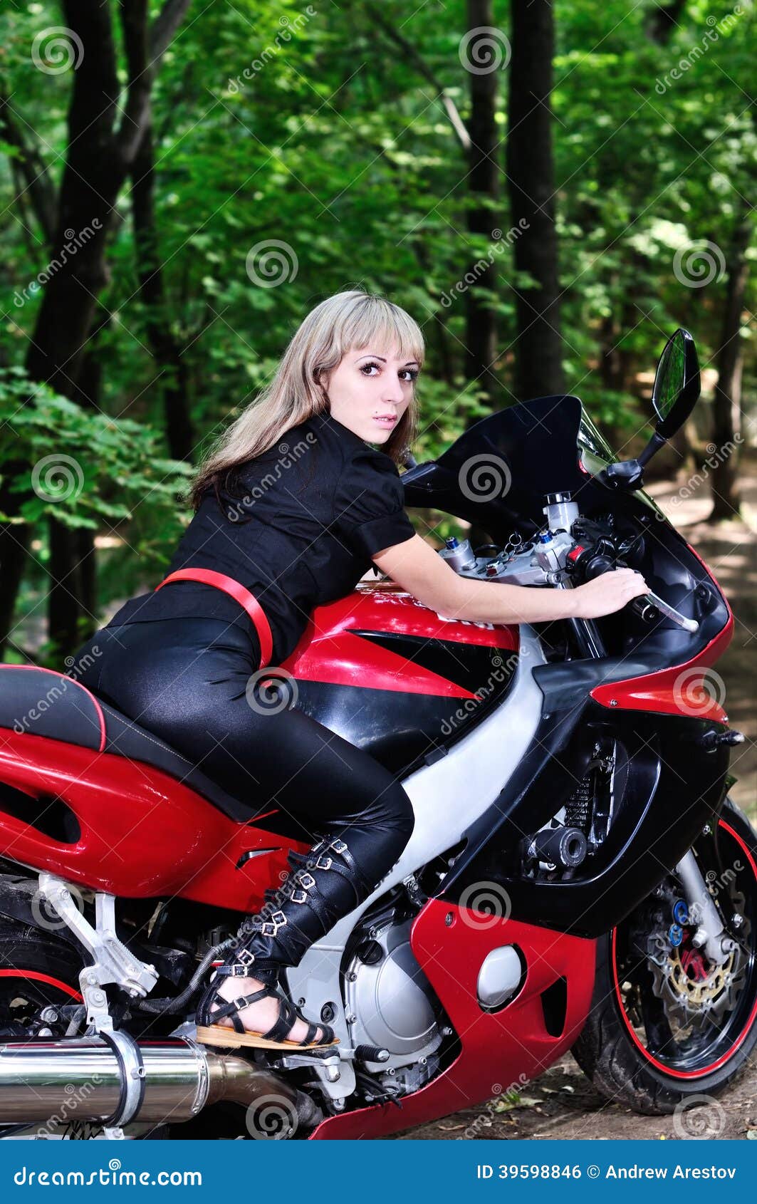 The Girl On A Sports Bike In The Woods Is Looking Back Stock Photo