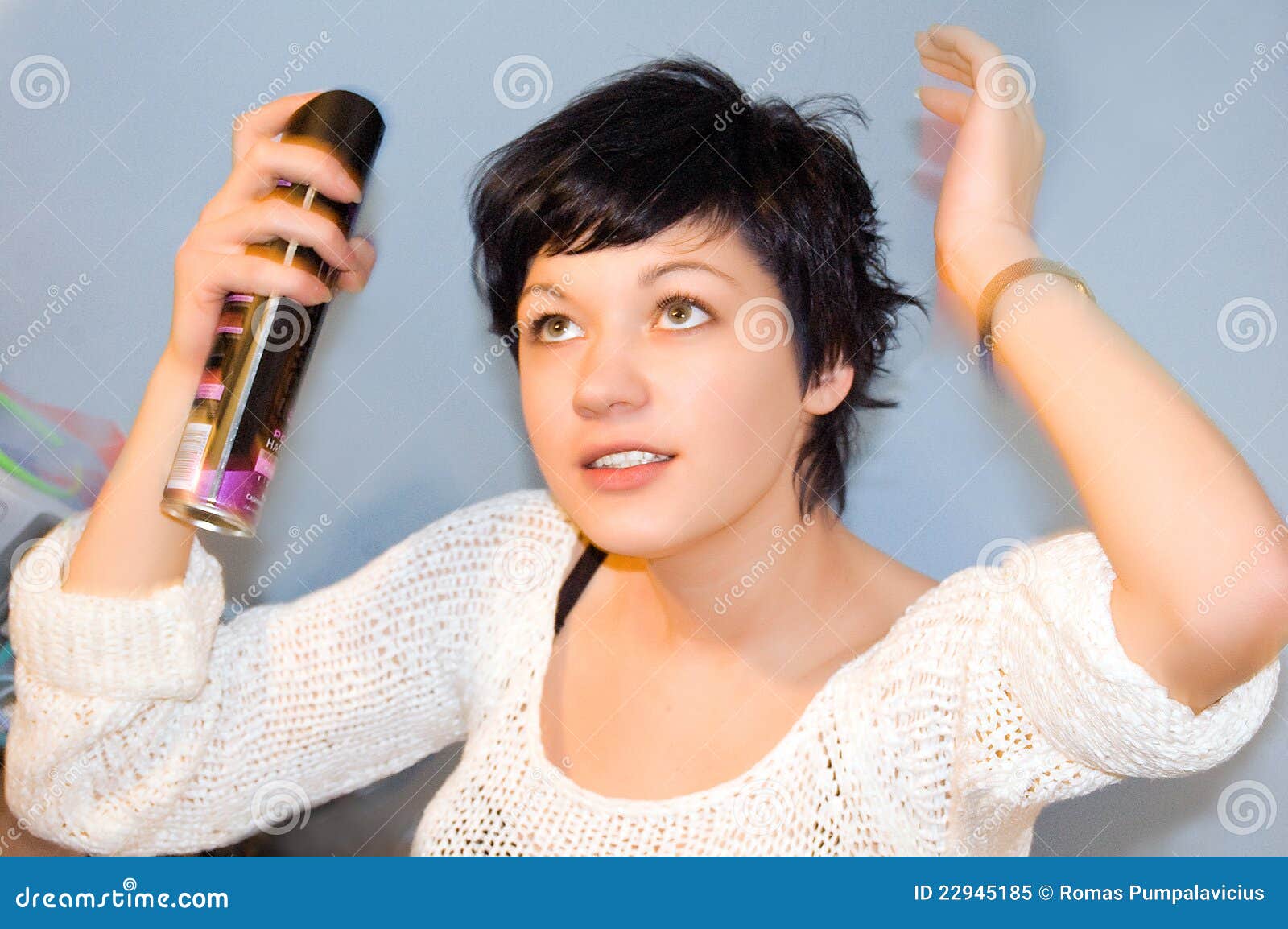 girl spraying hair lacquer onto her hair