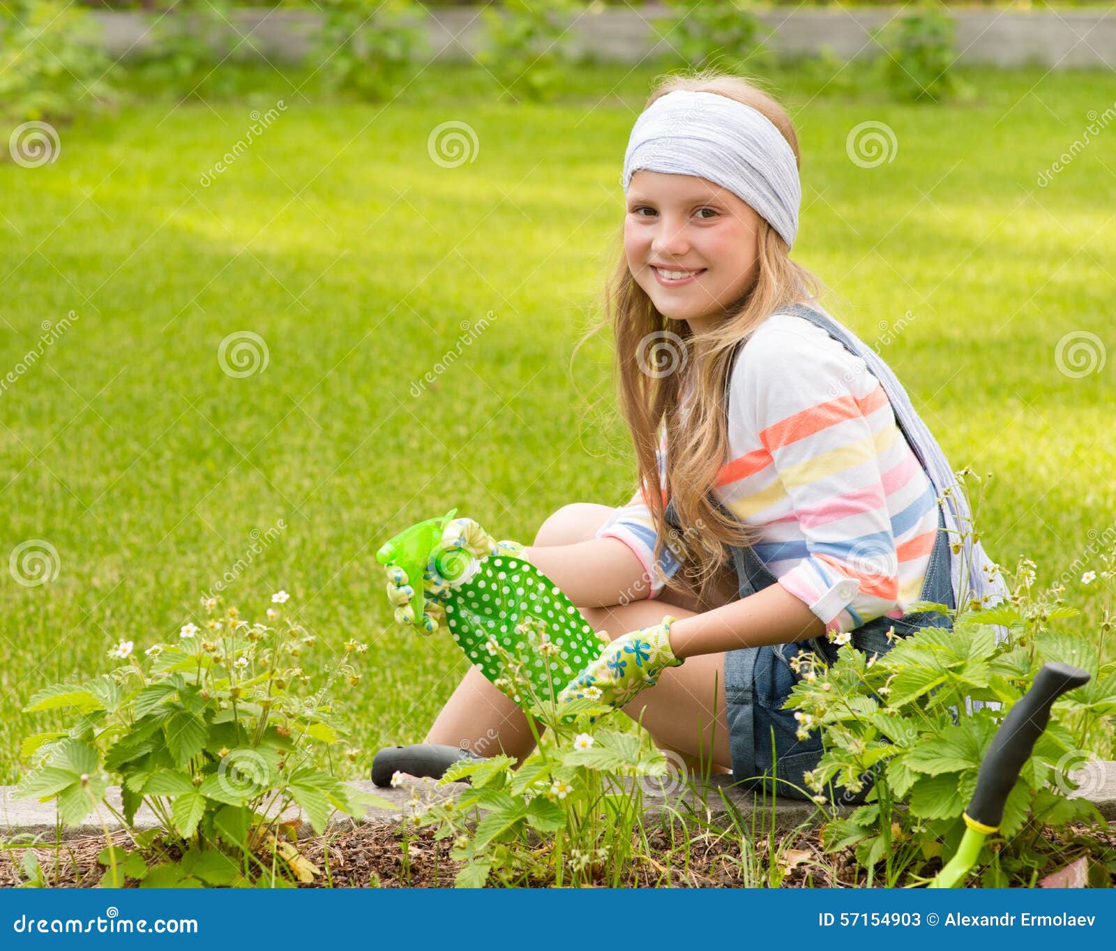 girl sprays plants in the garden