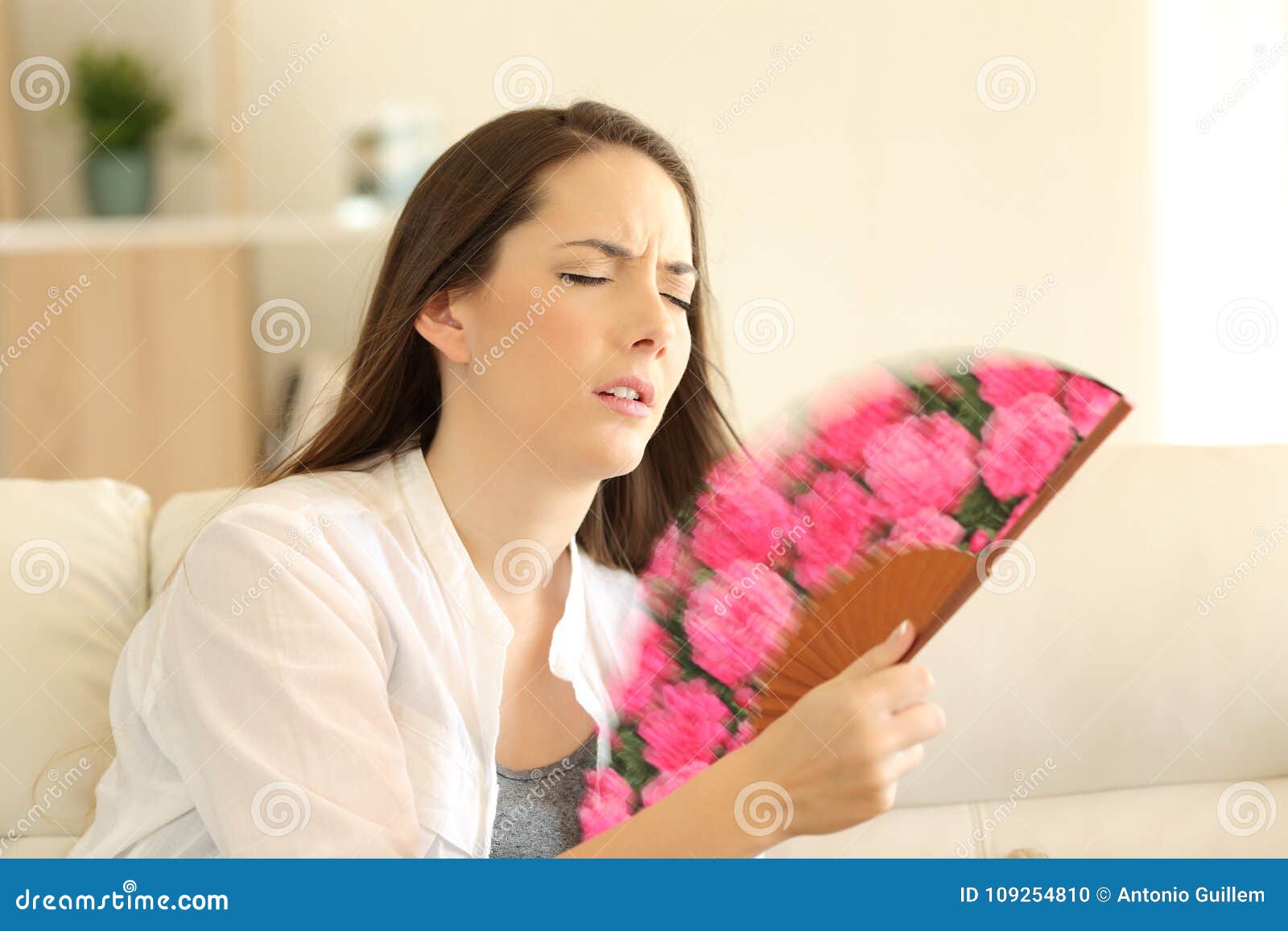 girl suffering a heatstroke fanning at home