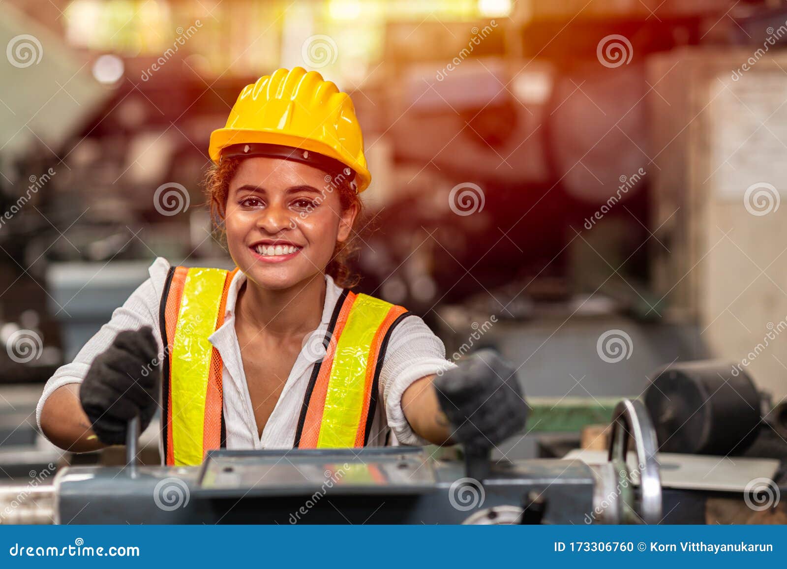girl teen worker with safety helmet happy smiling working labor in industry factory with steel machine